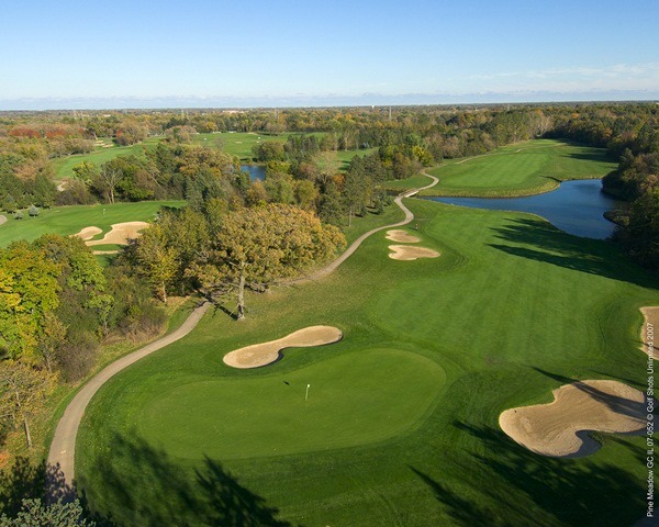 Aerial view of Hole 13 green and fairway with sand traps and bordered by trees