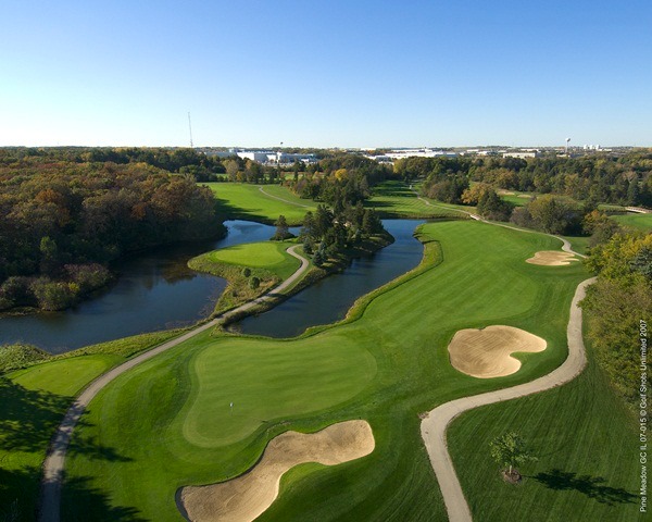 Aerial view of Hole 14 green and fairway, bordered by sand traps and a water hazard