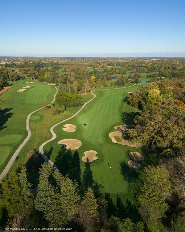 Aerial view of Hole 15 green and fairway bordered by trees and an adjacent hole