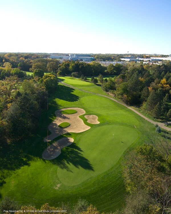 Aerial view of Hole 17 green and fairway with sand trap and trees casting long shadows