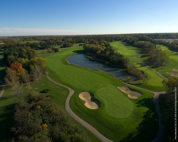 Aerial view of Hole 3 green with sand traps on either side with the fairway doglegging around a large water hazard