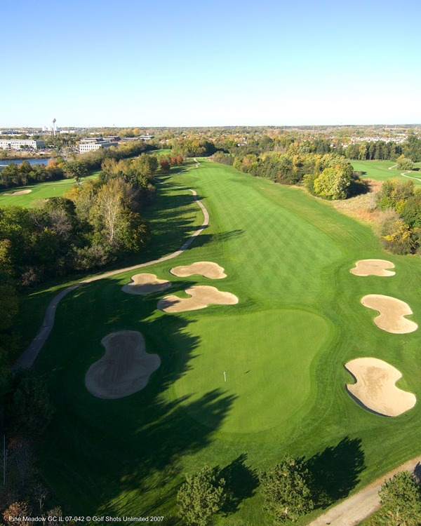 Aerial view of Hole 4 green leading out to a long straight fairway lined by trees