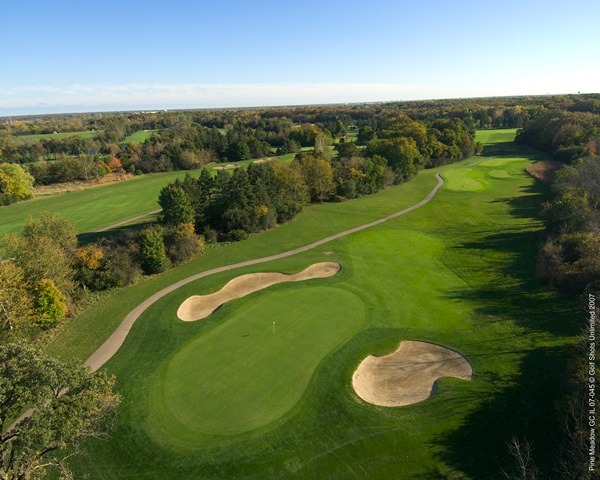 Aerial view of Hole 5 green and wide, tree-lined fairway