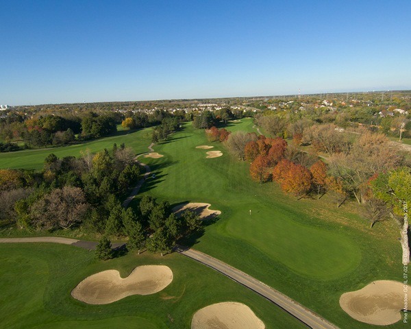Aerial view of Hole 9 green and fairway with sand traps and trees on either side